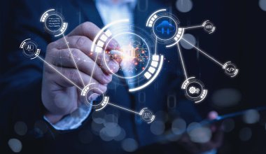 Koyu takım elbiseli profesyonel bir işadamı yapay zeka ve bulut bilgisayarıyla etkileşimde bulunuyor. Dijital dönüşüm konsepti iş dünyasında yapay zeka teknolojisi ağını geliştirdi.