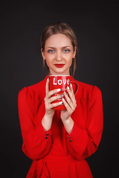 Wunderschöne junge Dame in rotem Kleid über schwarzem Hintergrund — Stockfoto