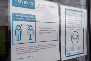 Toronto, Ontario, Kanada - 03 / 16 / 2021: Müşteriye gıda çıkarma konsepti sırasında Covid-19 Coronavirus 'un yayılmasını önlemek için sınırlama uyarısı girişi imzalayın.