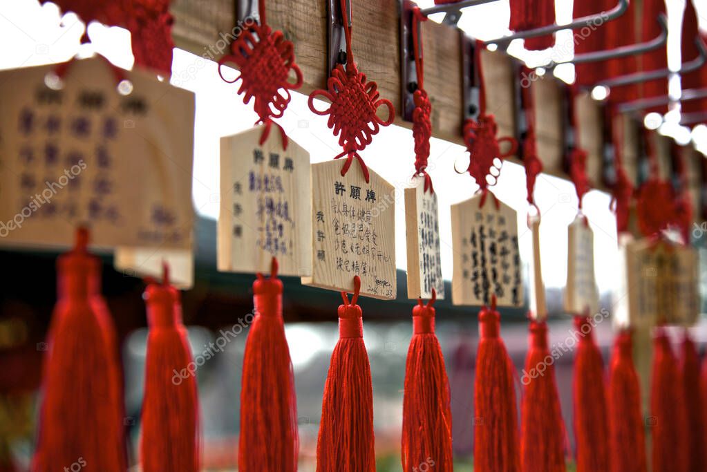 Close up of wooden plaques bearing prayers or wishes hanging up at the Buddhist temple in Toronto, Ontario, Canada