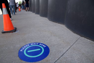 Aşı merkezinin girişinde yere sosyal uzaklık belirtileri var..