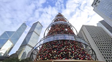 Arka planda ofis kuleleri olan bir Noel ağacının alçak açılı görüntüsü, Hong Kong, Çin