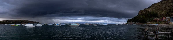 ボリビア コパカバーナのボートと曇った暗い空を持つチティカカ湖のパノラマ風景 — ストック写真