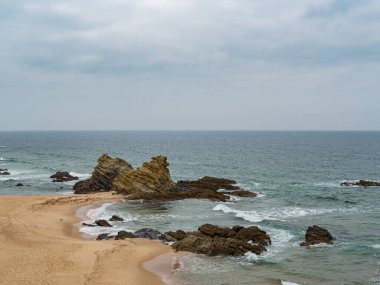 Kosta Vicentina, Algarve, Portekiz 'de devasa kayalar ve fırtınalı hava, yalnızlık ve yalnızlıkla dolu bir sahil.