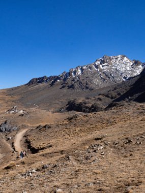 Huancayo, Peru 'da buzla kaplı bir dağa giden yolda insanlarla manzara