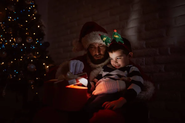 Άγιος Βασίλης Και Ένα Χαριτωμένο Αγοράκι Κάθονται Στο Σκοτάδι Και — Φωτογραφία Αρχείου