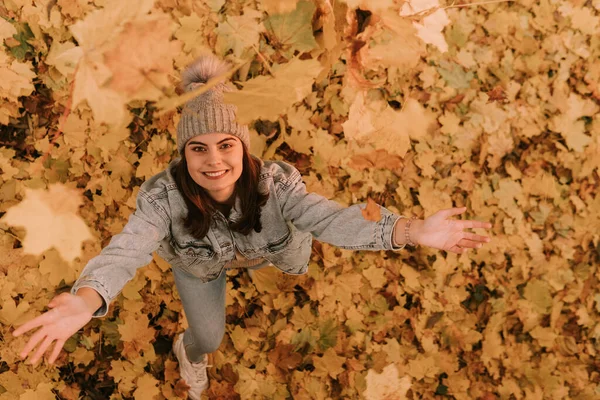 단풍잎을 던지면서 청바지를 코카서스 소녀의 공원의 — 스톡 사진