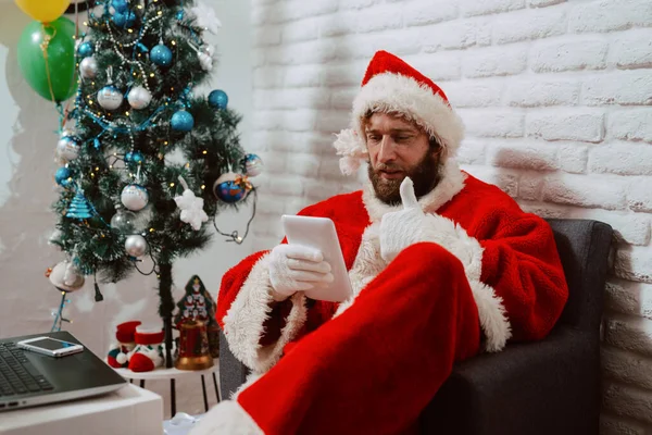 Jovem Barbudo Vestido Com Terno Papai Noel Senta Uma Poltrona — Fotografia de Stock