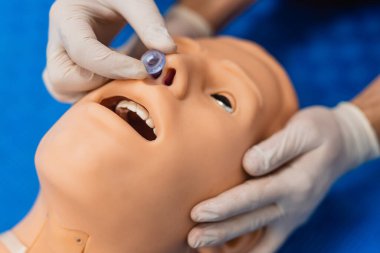 Ameliyathanedeki doktor burun yoluyla hastayı havalandırmak için burun tüpü taktığını gösteriyor. Kapat - ilk yardım