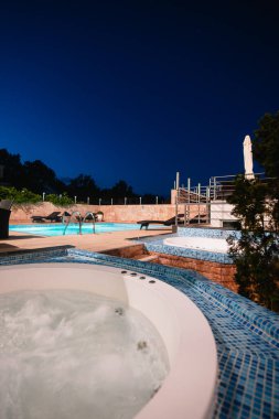 Otelin avlusunda büyük havuzun yanında küçük bir havuz. Deniz kıyısındaki bir tatil köyünde tatil