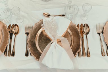 Kutlama ve parti için kırsal dekorasyonun en üst görüntüsü. Masada çatal bıçak takımı olan altın tabaklar