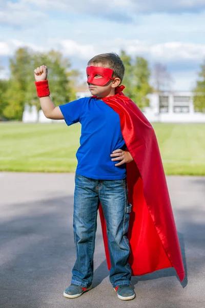 Superhelt stående med løftet arm - Stock-foto