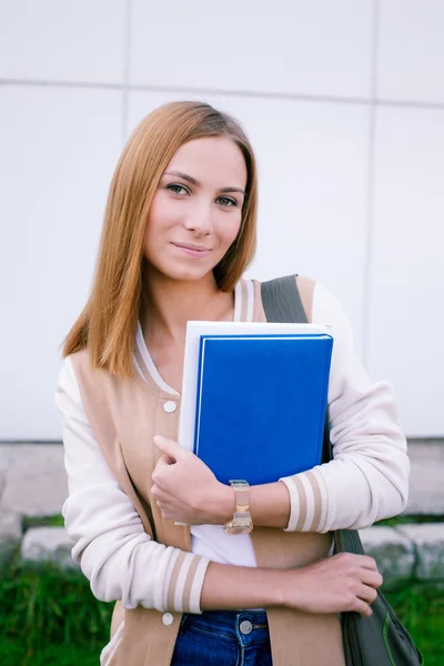 Student permanent met boek en camera te kijken — Stockfoto