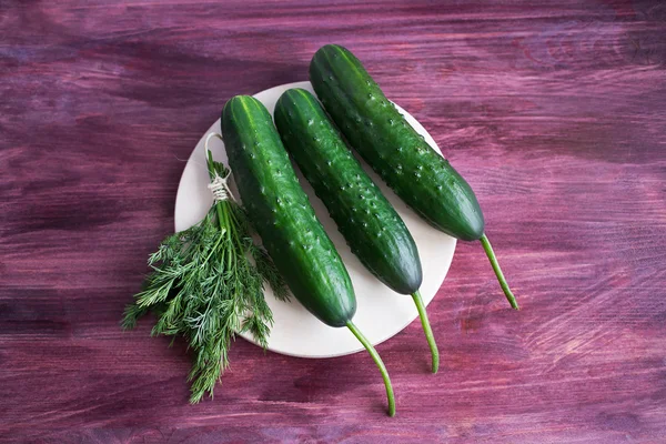 Three cucumbers and bunch of dill — Stock Photo, Image