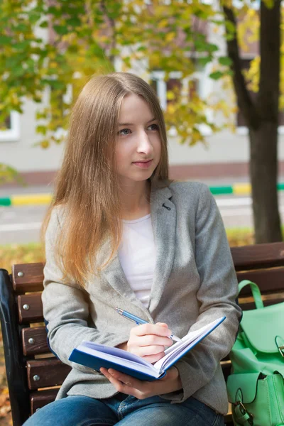 Student schreibt in Notizbuch — Stockfoto