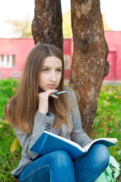 Student sitting under tree and thinking — Stock Photo, Image