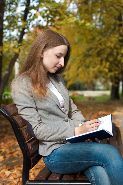 Schüler schreiben per Stift in Notizbuch — Stockfoto