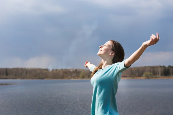 Sproeterig gelukkig meisje met gesloten ogen lacht om zon — Stockfoto