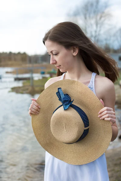 Freckled happy girl holding hat and looking to the side — Stock Photo, Image