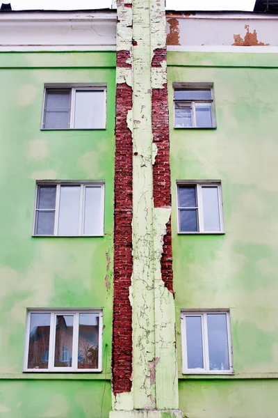 Yeşil kırmızı tuğla ev üzerinde sıva kırık