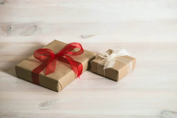 Caja de regalo con cinta roja en una mesa de madera blanca . —  Fotos de Stock