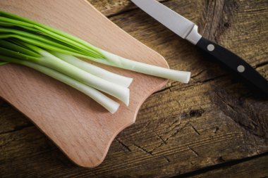 Ahşap zemin üzerine yeşil soğan. Pişirme