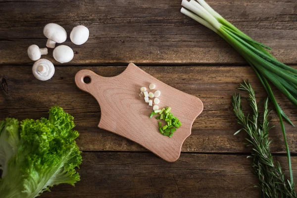 Salat mit Rosmarin und grünen Zwiebeln und Pilzen auf den Brettern. Kochen — Stockfoto