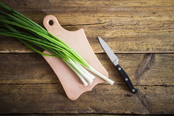 Grüne Zwiebeln auf Holzgrund. Kochen — Stockfoto