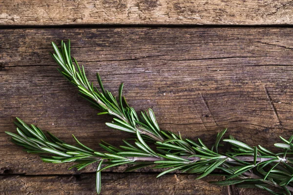 Rozemarijn op de houten achtergrond — Stockfoto