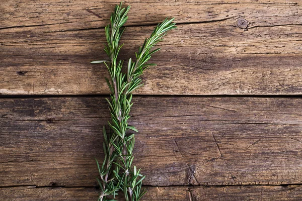 Rozemarijn op de houten achtergrond — Stockfoto