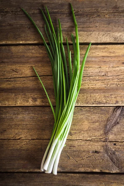 Groene uien op houten achtergrond. Koken — Stockfoto