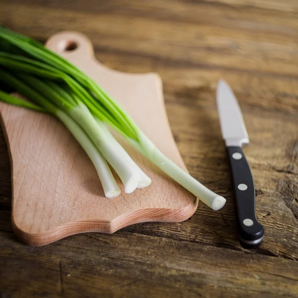 Grüne Zwiebeln auf Holzgrund. Kochen — Stockfoto