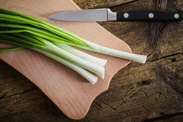 Grüne Zwiebeln auf Holzgrund. Kochen — Stockfoto