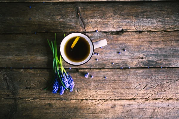 Niebieskie kwiaty i filiżankę herbaty na drewniane tła. Vintage — Zdjęcie stockowe