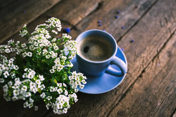 Белые цветы с чашкой кофе на старом деревянном фоне — стоковое фото