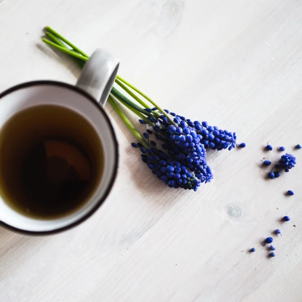 Fleurs bleues et tasse de thé sur fond en bois. Vintage — Photo