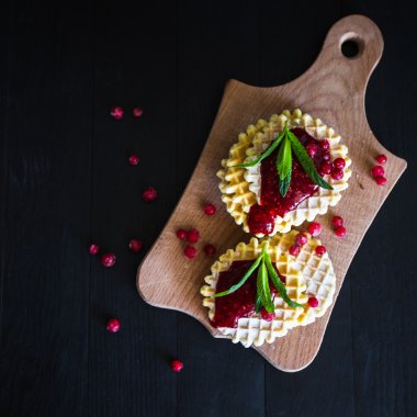 Berry reçel ile pudra şekeri waffle ve siyah arka plan üzerine nane