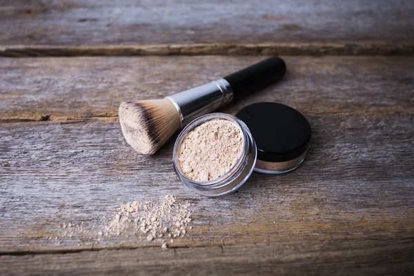 mineral powder of different colors with a brush for make-up on wooden background