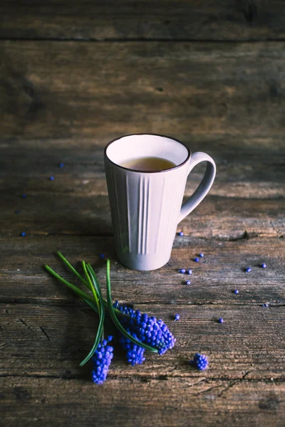 Синие цветы и чашка чая на деревянном фоне. Винтаж — стоковое фото