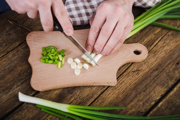 Groene uien op houten achtergrond. Koken — Stockfoto