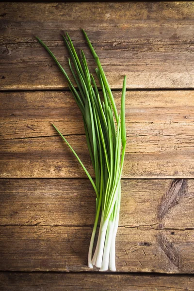 Cebolas verdes em fundo de madeira. Cozinhar — Fotografia de Stock