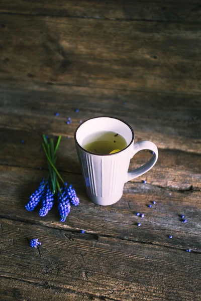 Fleurs bleues et tasse de thé sur fond en bois. Vintage — Photo