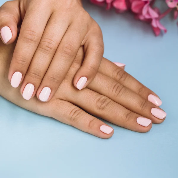 Mooie vrouw met mooie roze manicure nagels — Stockfoto