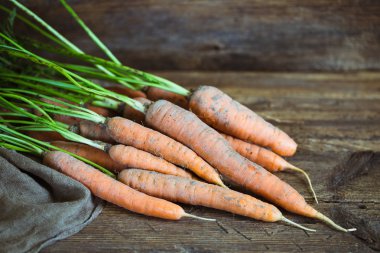 Köy ahşap arka planda taze havuçlar.