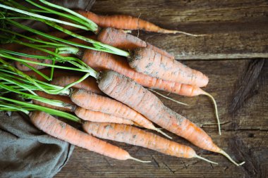 Köy ahşap arka planda taze havuçlar.