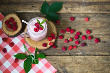 Payet rustik ahşap arka plan üzerinde bir mason kavanoza pembe ahududu güler yüzlü