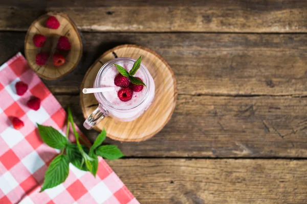 Rosa Himbeer-Smoothie im Einmachglas mit Strohhalmen auf rustikalem Holzhintergrund — Stockfoto