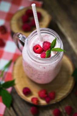 Payet rustik ahşap arka plan üzerinde bir mason kavanoza pembe ahududu güler yüzlü