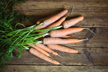 Köy ahşap arka planda taze havuçlar.