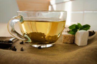 ahşap masa üzerine nane ile çay bardağı